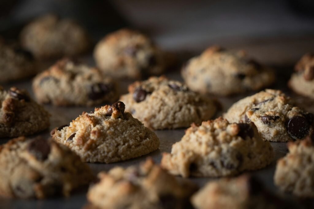 A close-up shot of freshly baked chocolate chip cookies on a tray, showcasing their texture and indulgence.