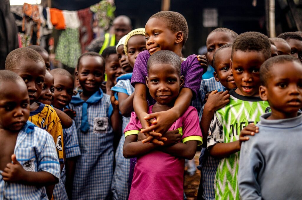 A heartwarming group of children smiling and embracing each other outdoors, showcasing joy and community.