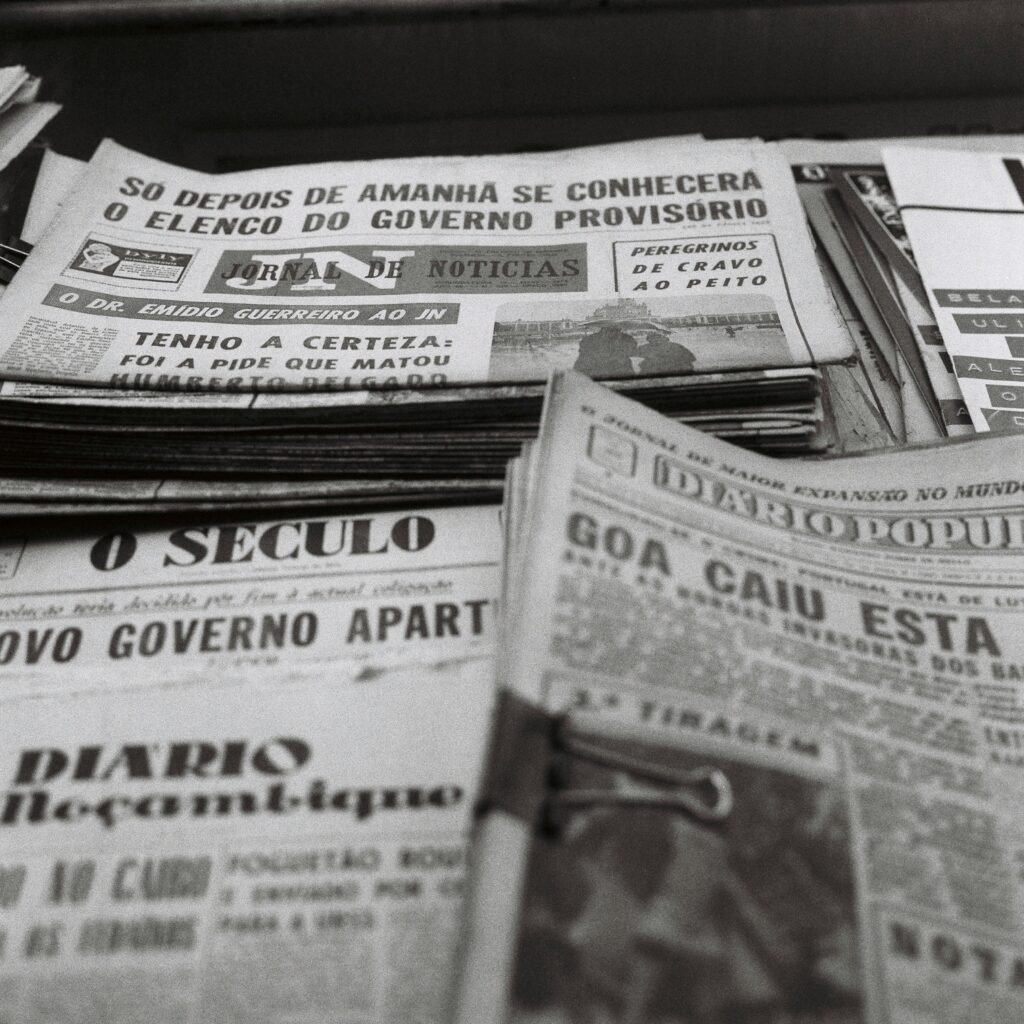A nostalgic view of vintage Portuguese newspapers stacked together, showcasing historical headlines.
